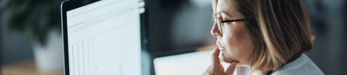 woman with glasses viewing computer screen