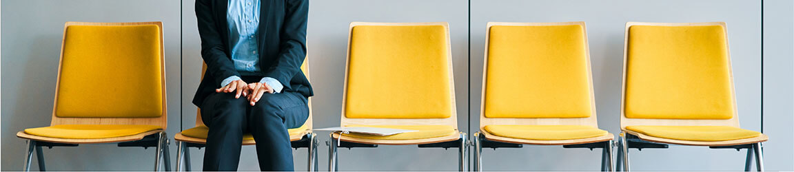 une personne assise dans une rangée de chaises jaunes