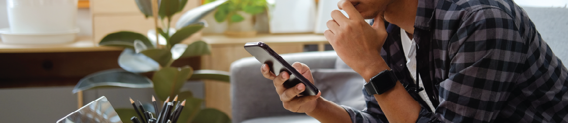 A person leans while sitting on a chair and looking at their phone.