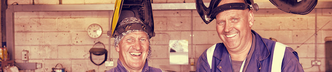 Two welders smiling