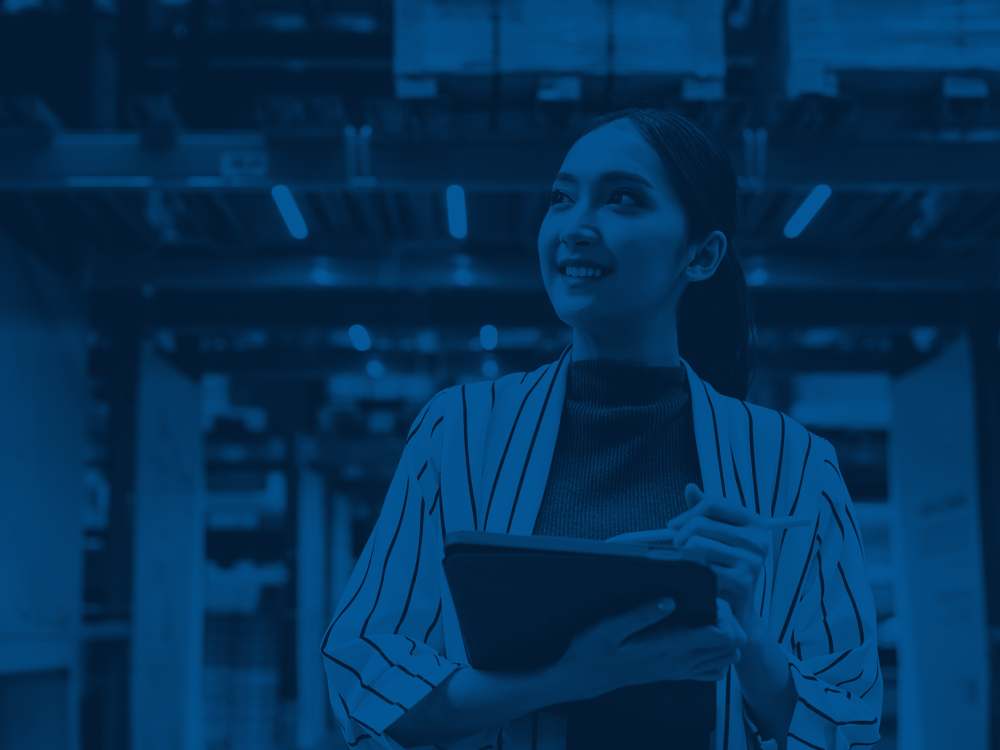 A woman holding a tablet in a warehouse