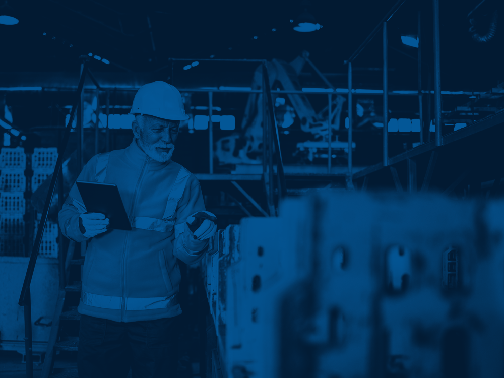 A male worker in a hard hat inspects machinery